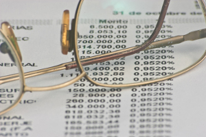 Paire de lunettes posées sur une feuille de comptes